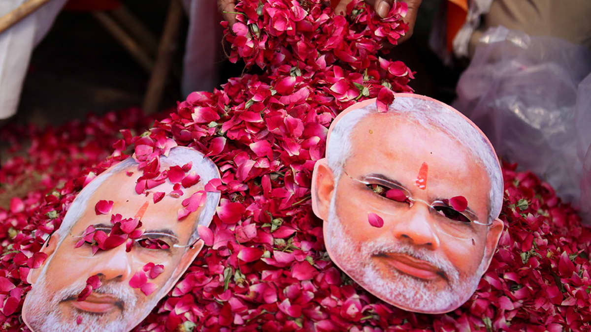 Hindunationalistisen BJP-puolueen Narendra Modia esittäviä naamareita ruusupedillä.
