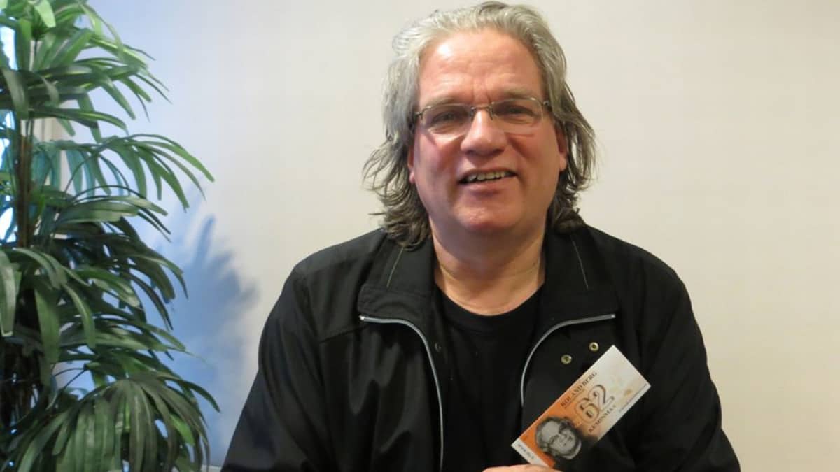 Roland Berg kädessään eurovaalikampanjaansa varten painatettu "vaaliraha".