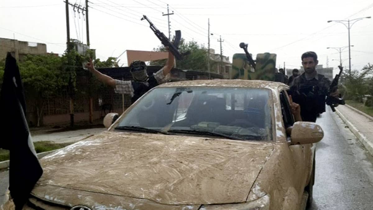 Ääri-islamilaisen ISIS-järjestön taistelijat ajavat paraatissa Mosulin läpi käyttäen autoja, jotka he olivat ottaneet haltuunsa paenneilta Irakin turvallisuusjoukoilta.
