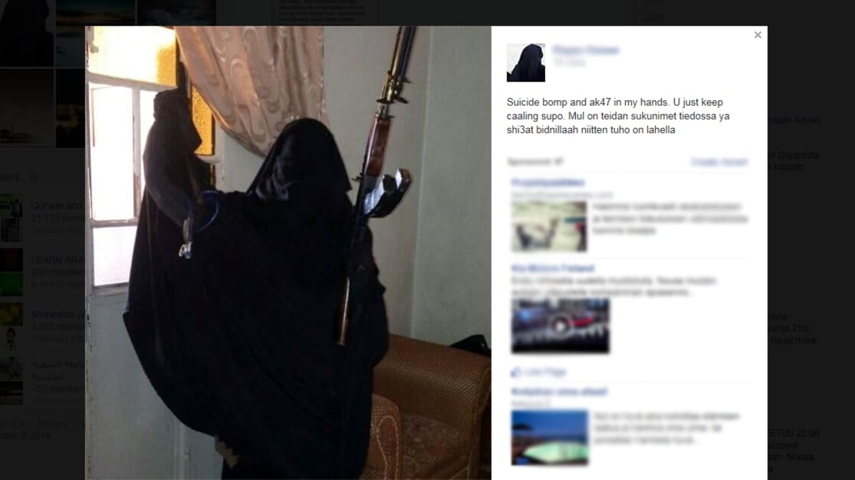 Burkhaan pukeutunut nainen poseeraa aseen kanssa facebook-sivustollaan. 