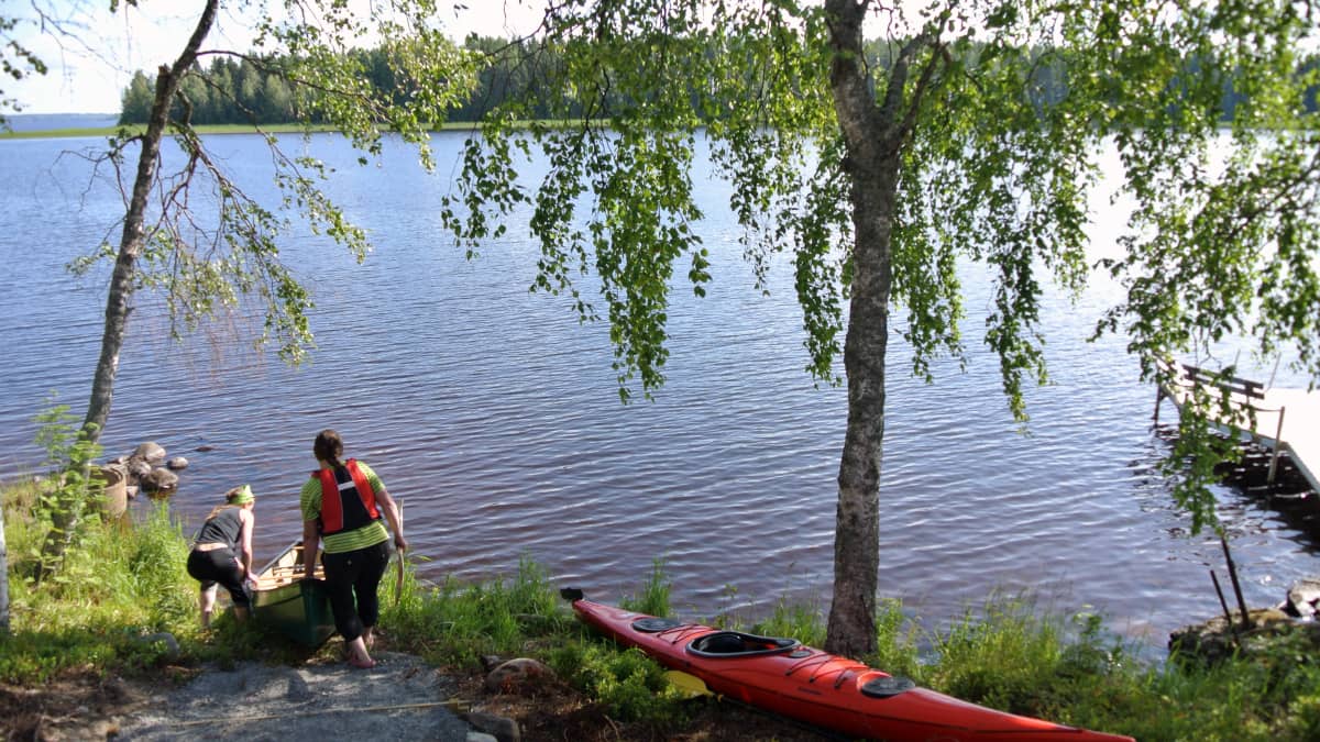 Kyrönjoen KoskiHäjyjen naiset laskevat kanoottia veteen Lappajärvellä. 
