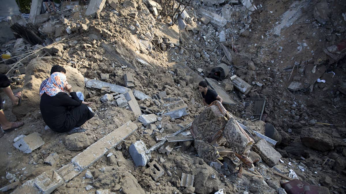Palestiinalaismies kerää tavaroitaan Israelin ilmaiskussa tuhoutuneesta kodistaan Beit Hanussa, Gazassa 9. heinäkuuta 2014. 