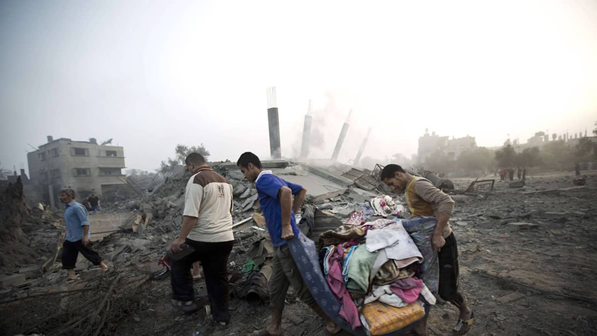 Palestiinalaiset keräsivät tavaroitaan Israelin ilmaiskussa tuhotuista kodeistaan Gazassa 8. heinäkuuta 2014. 