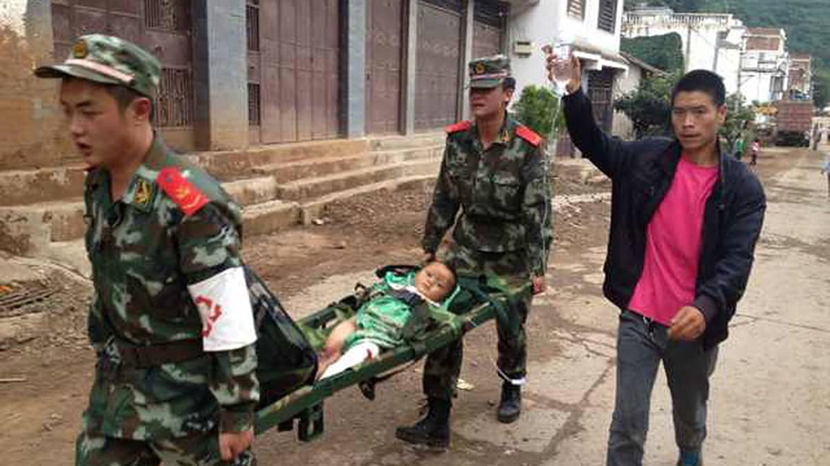 Maanjäristyksessä loukkaantunutta lasta kannettiin hoitoon Yunnanin maakunnassa sunnuntaina.