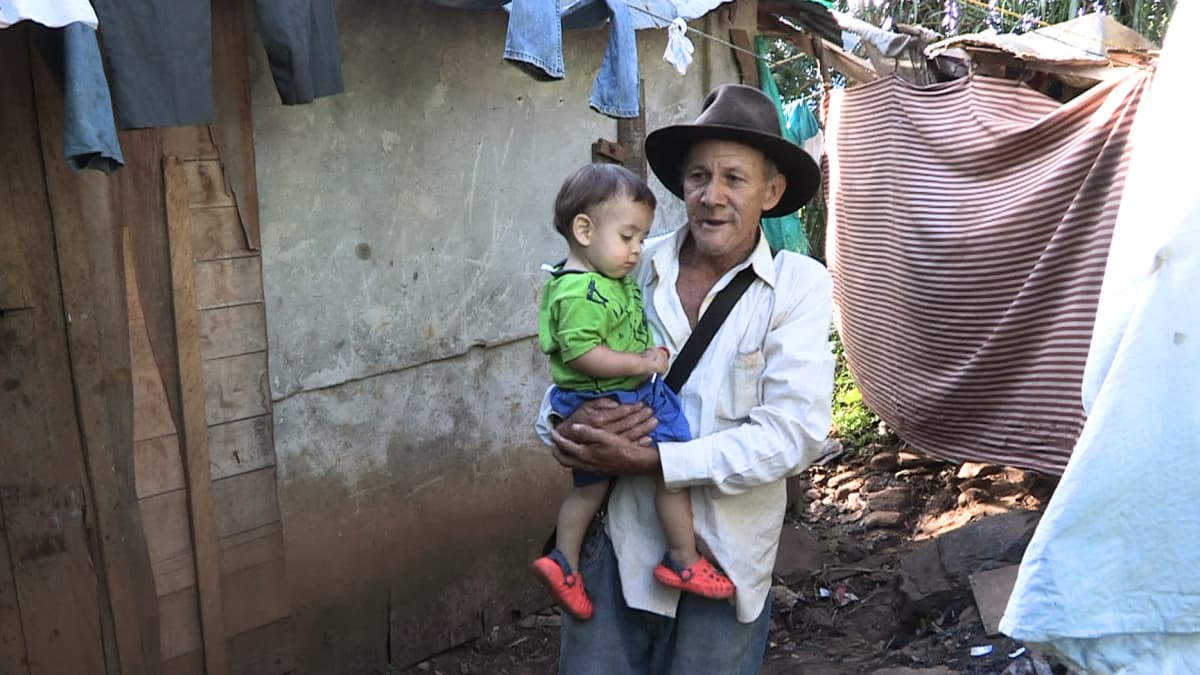 Maanviljelijä José Vicente Velasquez pikkulapsi sylissään. 