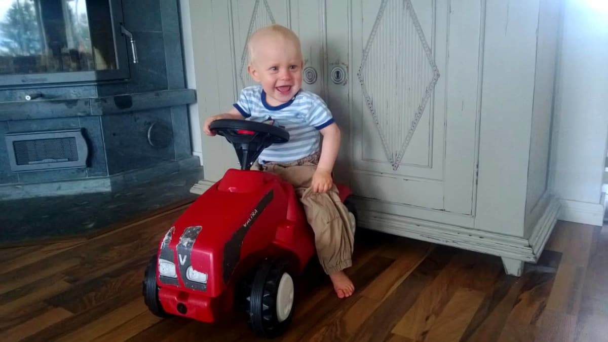 James 10 kuukauttaa leikkii traktorilla.