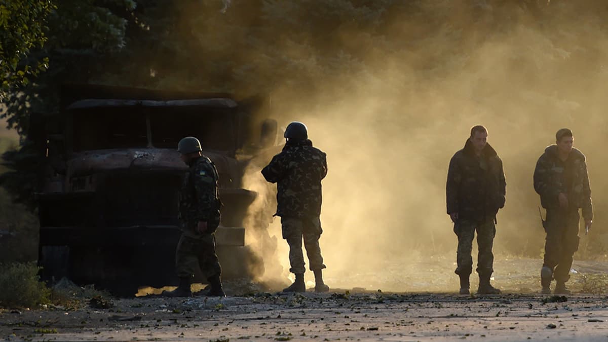 Ukrainalaissotilaat tarkastivat öisessä armeijan tarkastuspisteelle suunnatussa hyökkäyksessä tuhoutunutta armeijan ajoneuvoa Mariupolin lähistöllä 7. syyskuuta 2014. 