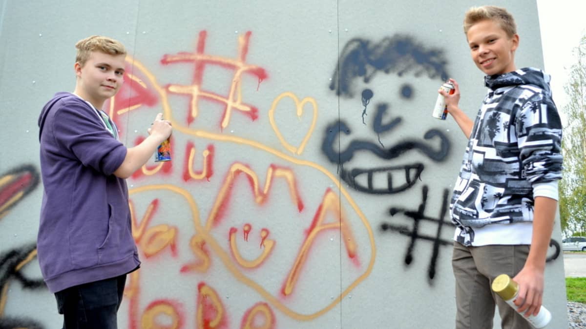 Nuoret pojat tekemässä graffiteja