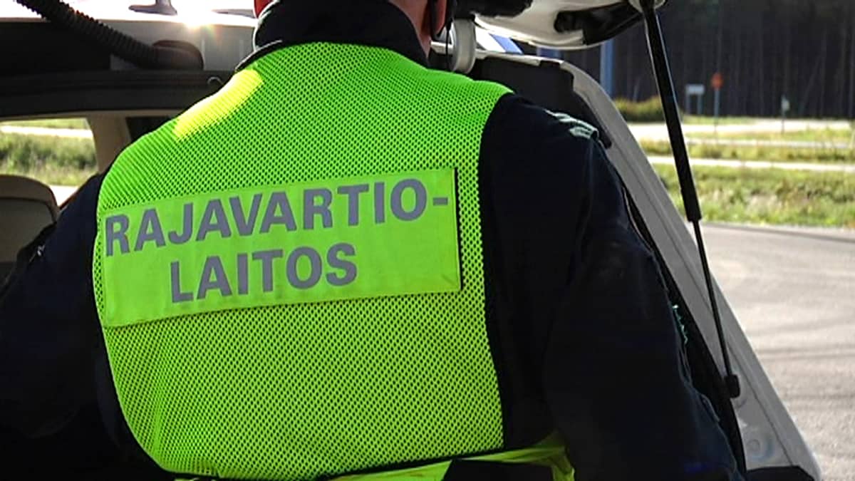 Rajavartija tutkii autoa Imatran raja-asemalla.