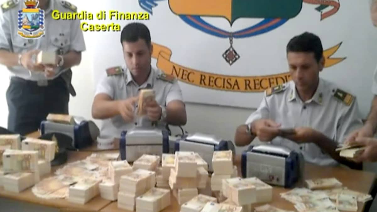 Italialaiset poliisit laskemassa takavarikoituja 50 euron seteleitä.