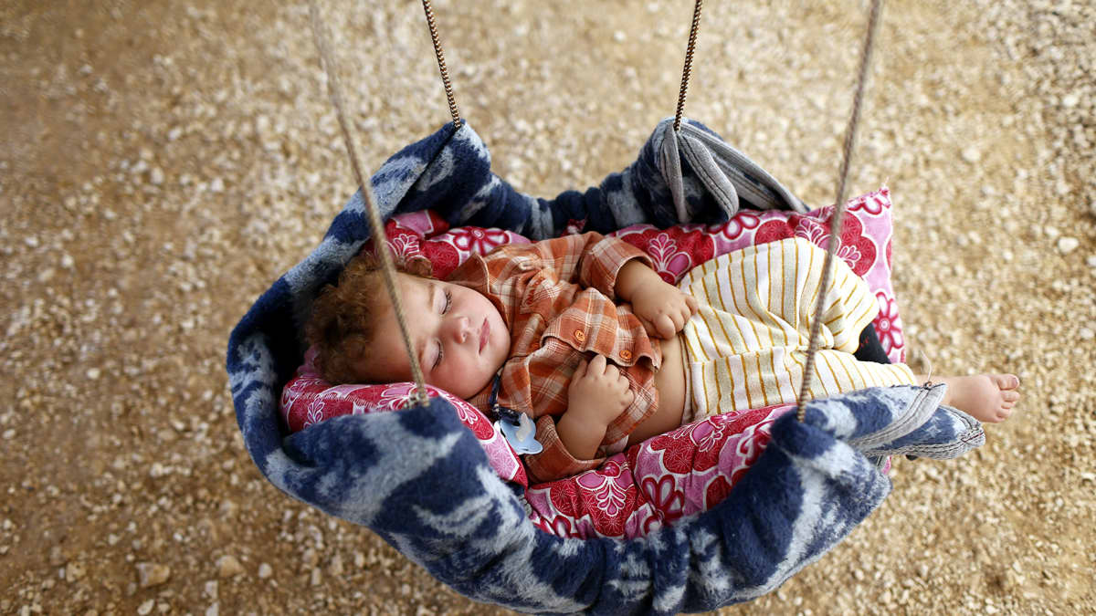 Syyrialainen taapero nukkui itsetehdyssä kehdossa teltassa pakolaisleirillä Surucin alueella, Turkissa 1. lokakuuta 2014.