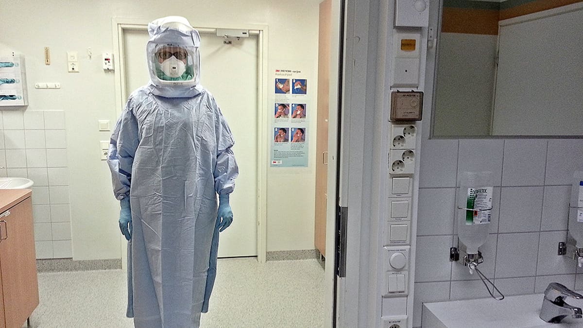 Ebolapotilaan hoitaja suojaa itsensä päästä varpaisiin.