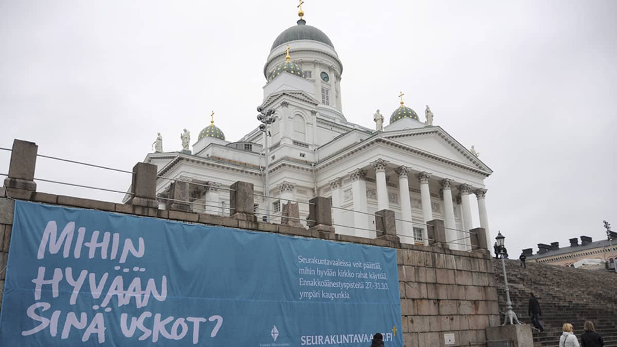 Mihin hyvään sinä uskot? -lause seurakuntavaaleista kertovassa mainoslakanassa Tuomiokirkon edustalla Senaatintorilla Helsingissä 28. lokakuuta 2014.
