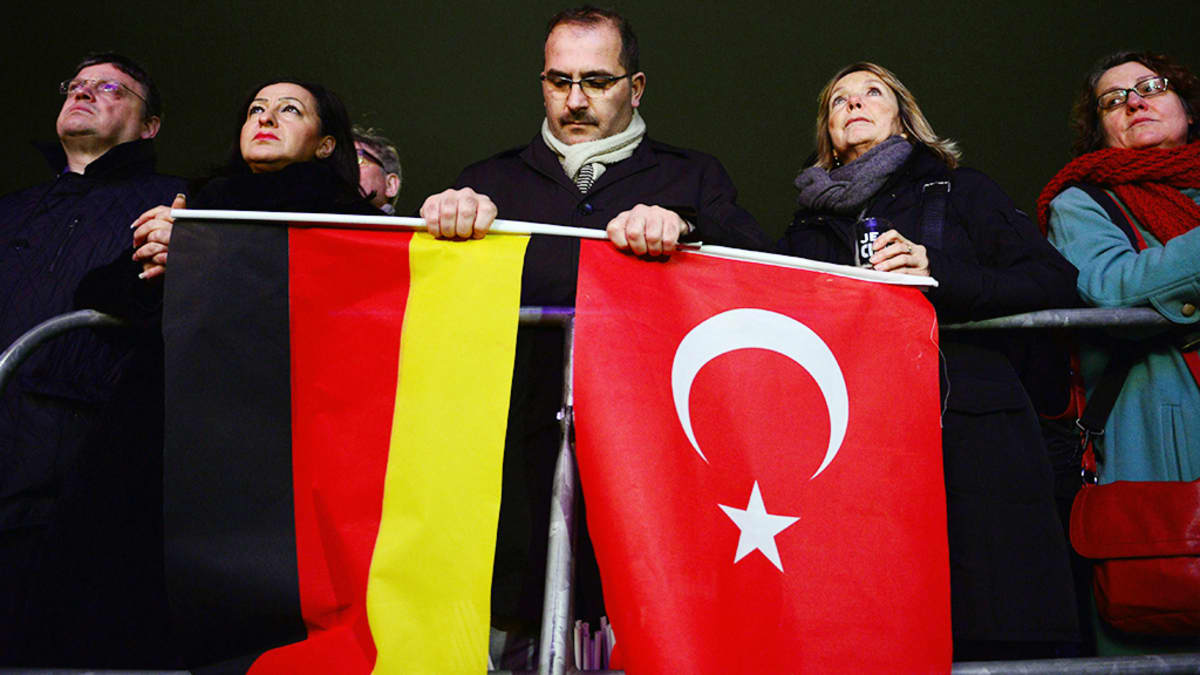Mielenosoittaja kantaa Saksan ja Turkin lippua Berliinissä.