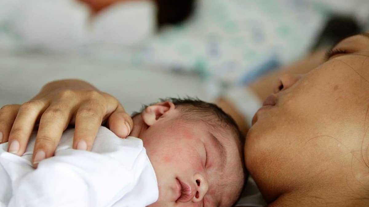 Vauva nukkuu äitinsä rinnalla manilalaisessa sairaalassa Filippiineillä.