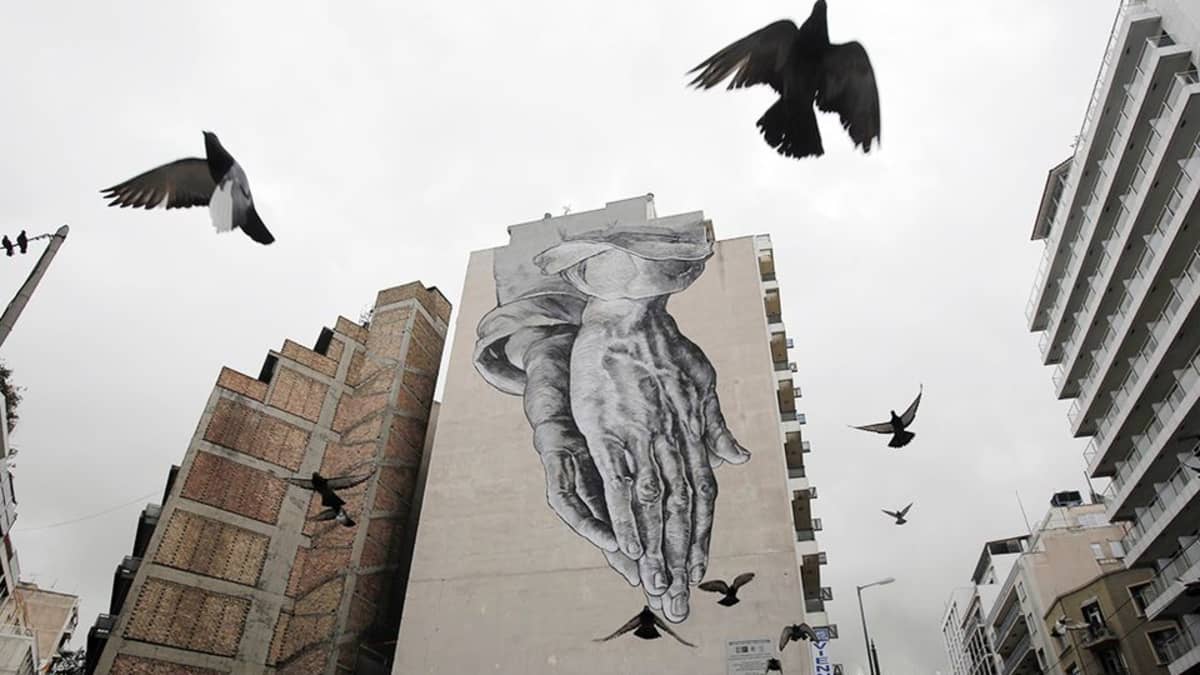 RAkennuksen seinään maalattu graffiti ja puluja Ateenan keskustassa 24. helmikuuta.