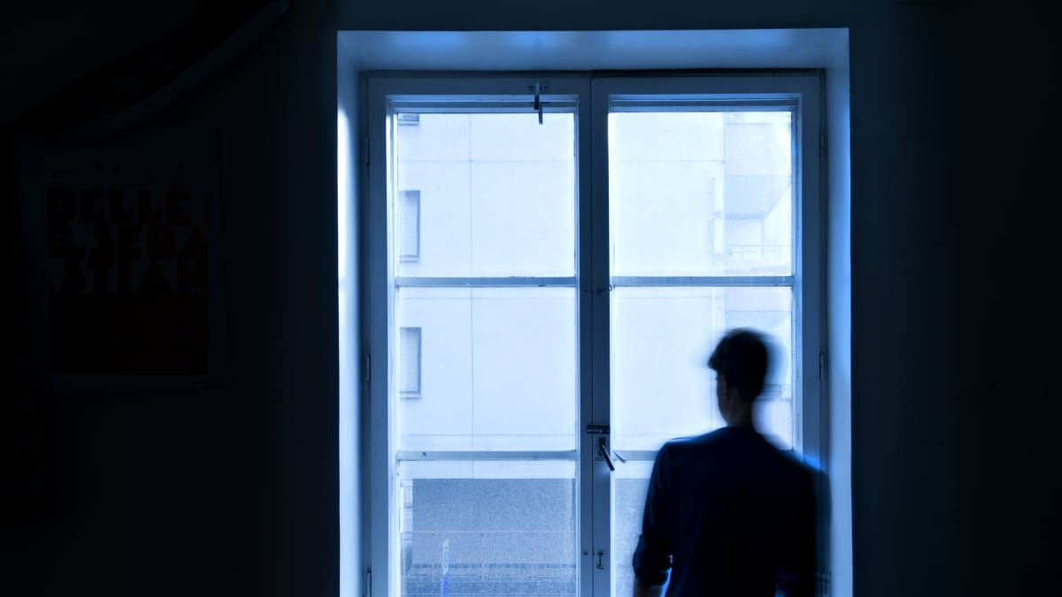 Ihminen seisoo ikkunan ääressä