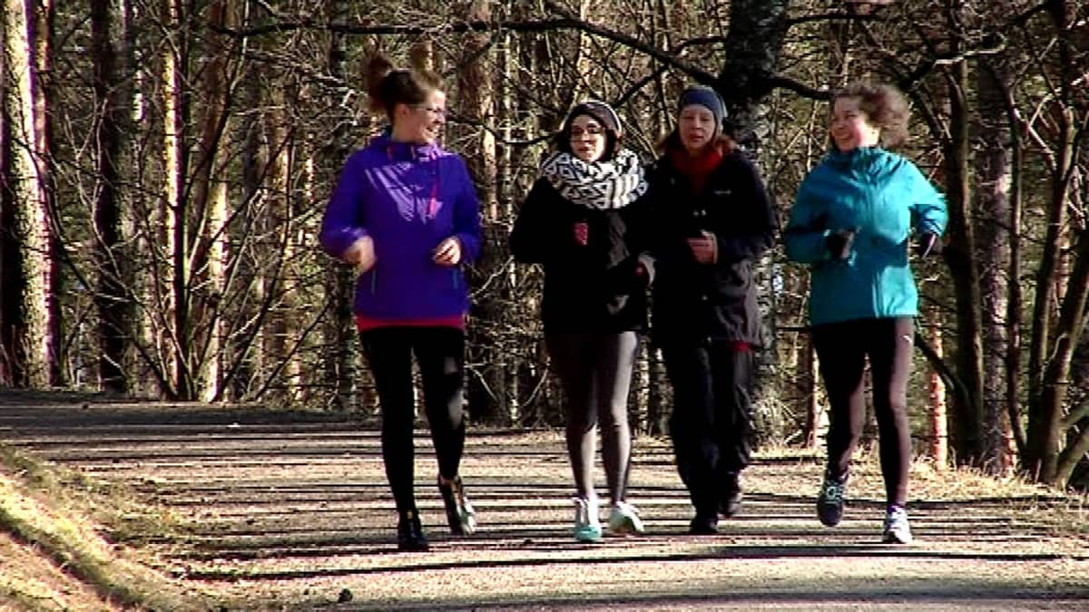 Neljä naista juoksee metsässä.
