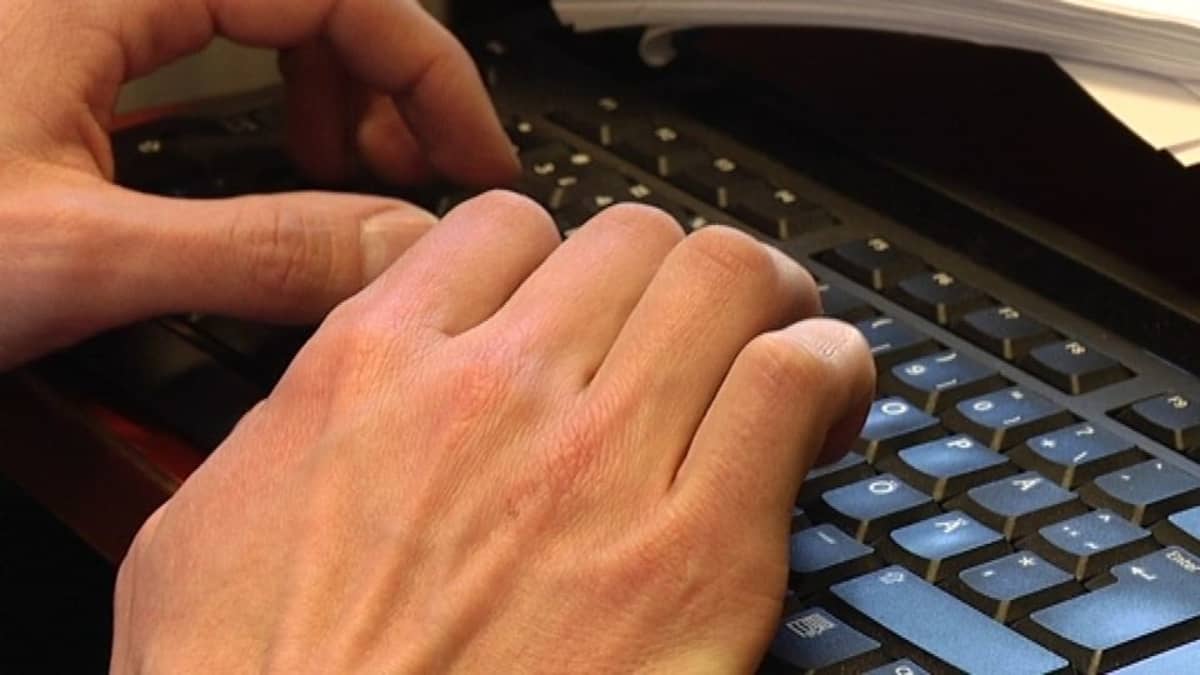 Tutkijan kädet tietokoneen näppäimillä.