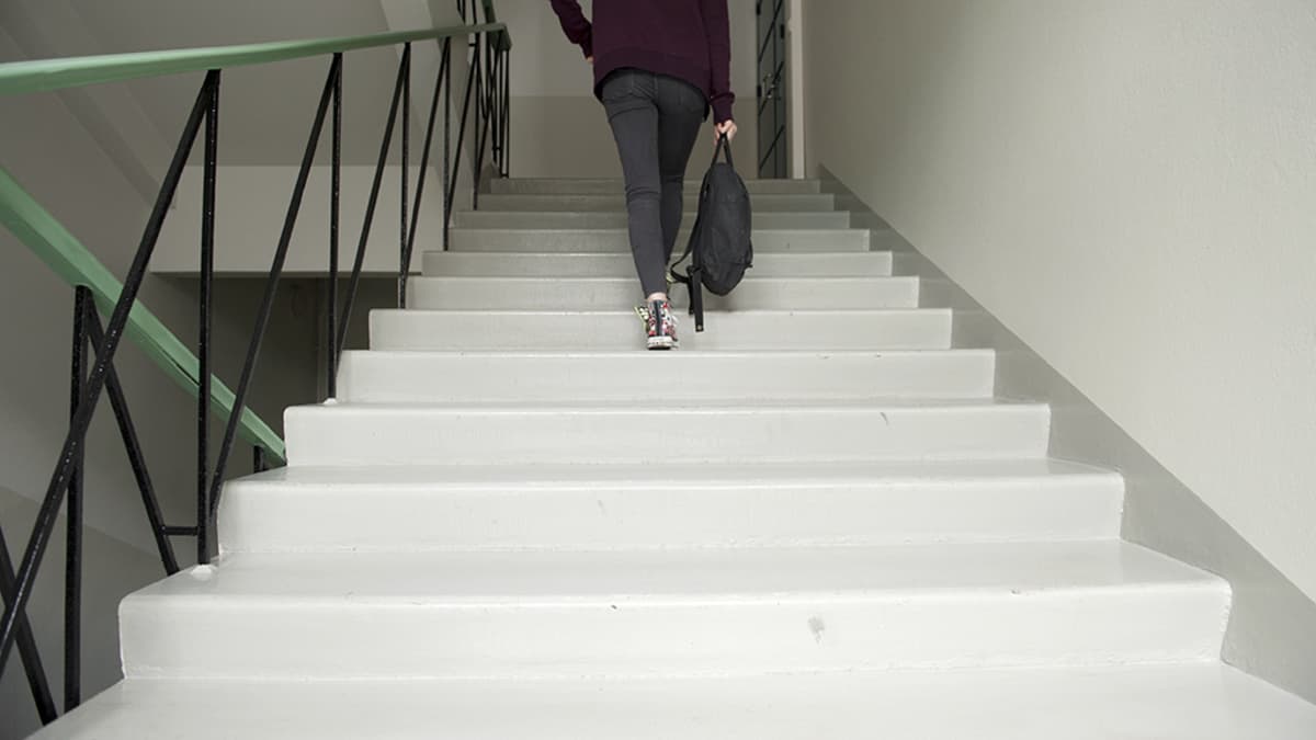 Nuori nainen kävelee ylös portaita.