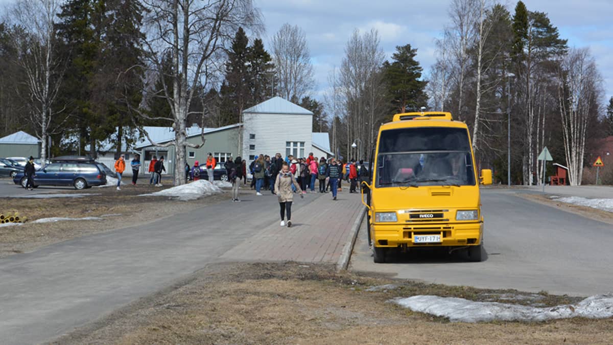 Koululaisia kävelemässä koulukuljetuksen kyytiin Simon Asemakylän koululla.