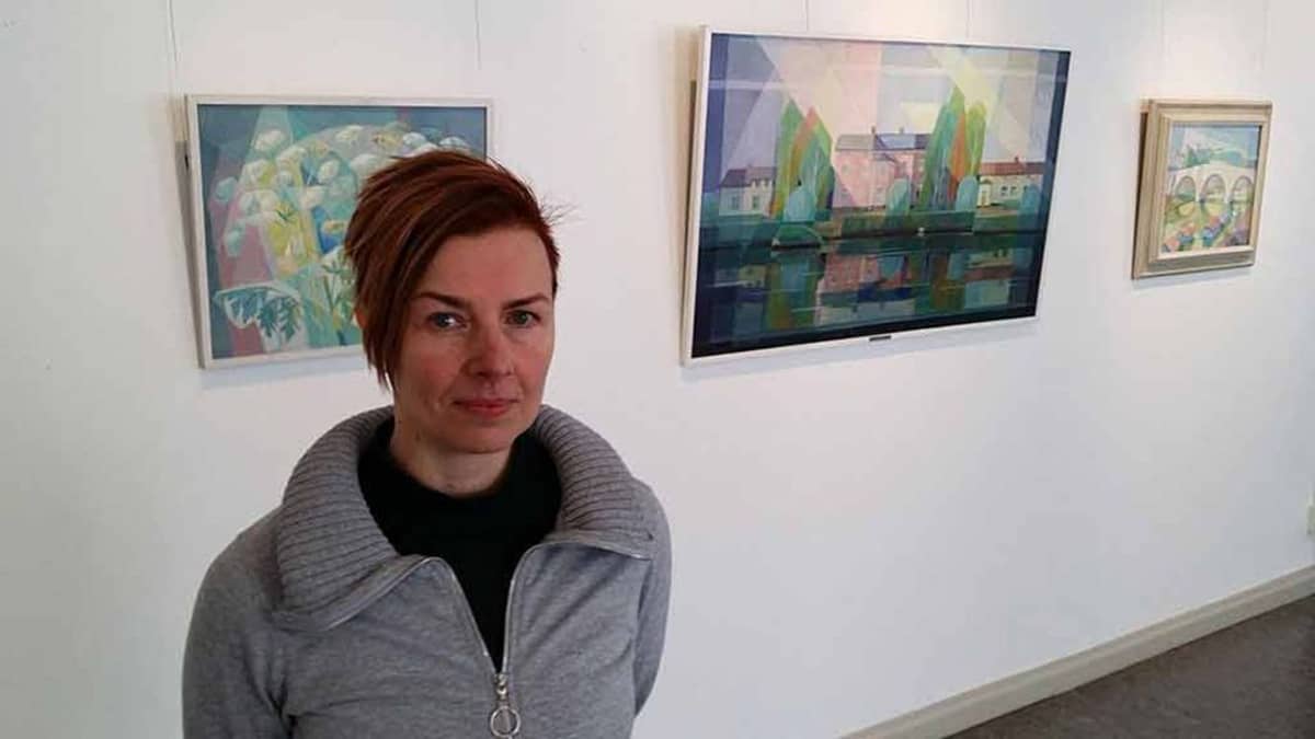 Kuvassa  arkistoamanuenssi Anna Liisanantti , taustalla Krokforsin tauluja.