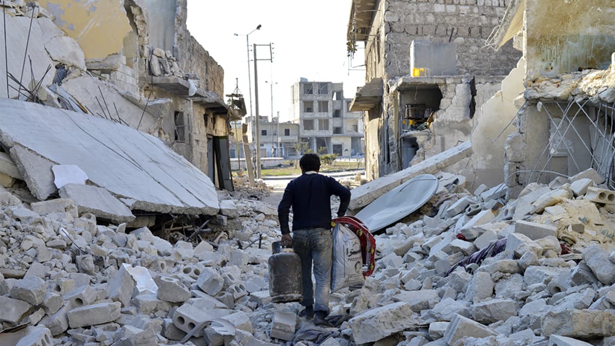 Mies kantoi omaisuuttaan sodan runtelemassa naapurustossa Aleppossa helmikuussa 2014.
