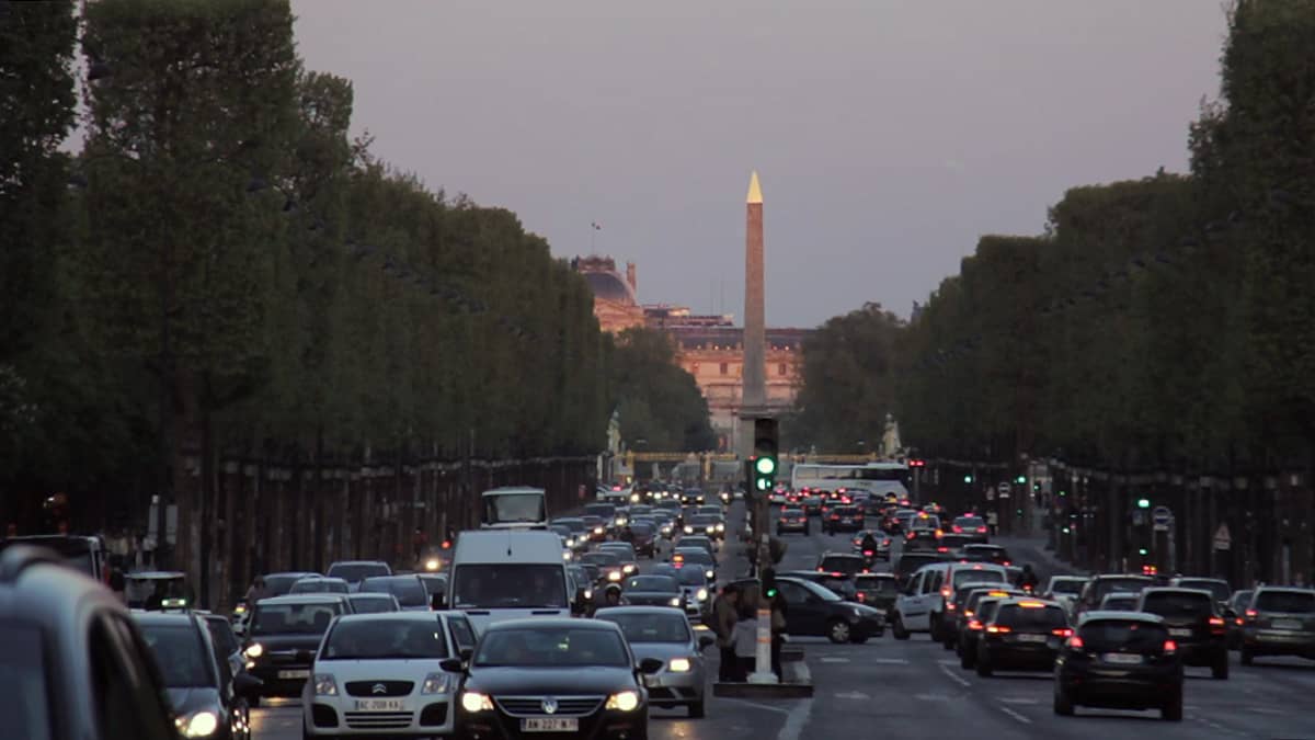 Autoja Pariisin liikenteessä iltahämärässä.