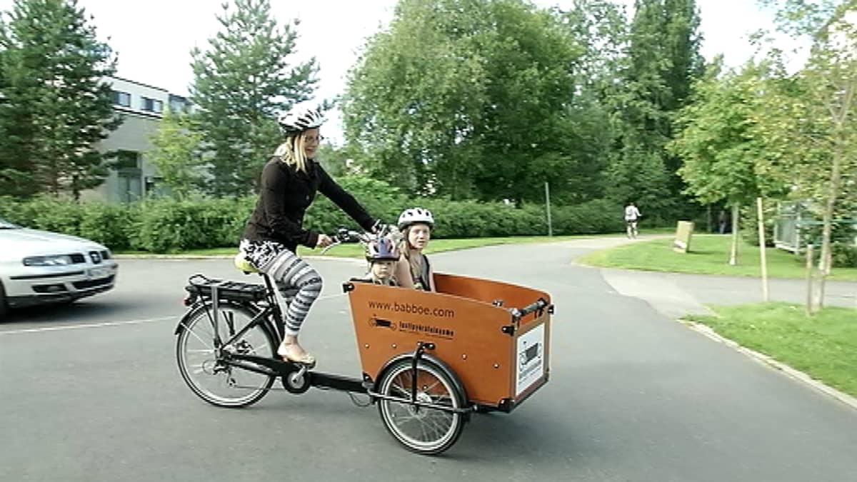 Perhepäivähoitaja Minna Kettunen kuljetti lastipyörällä parhaimmillaan neljää lasta kerrallaan. Laatikossa on turvavyöt neljälle lapselle.