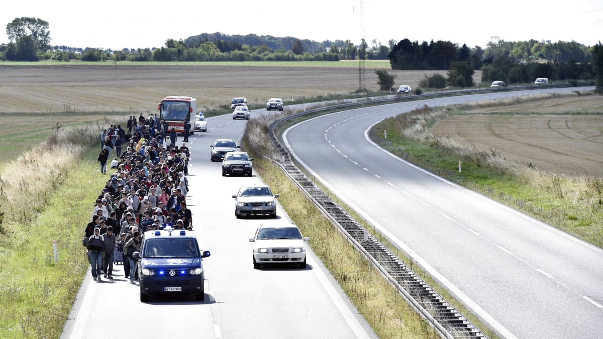 Turvapaikanhakijat kävelevät Tanskan ja Ruotsin välisellä moottoritiellä.