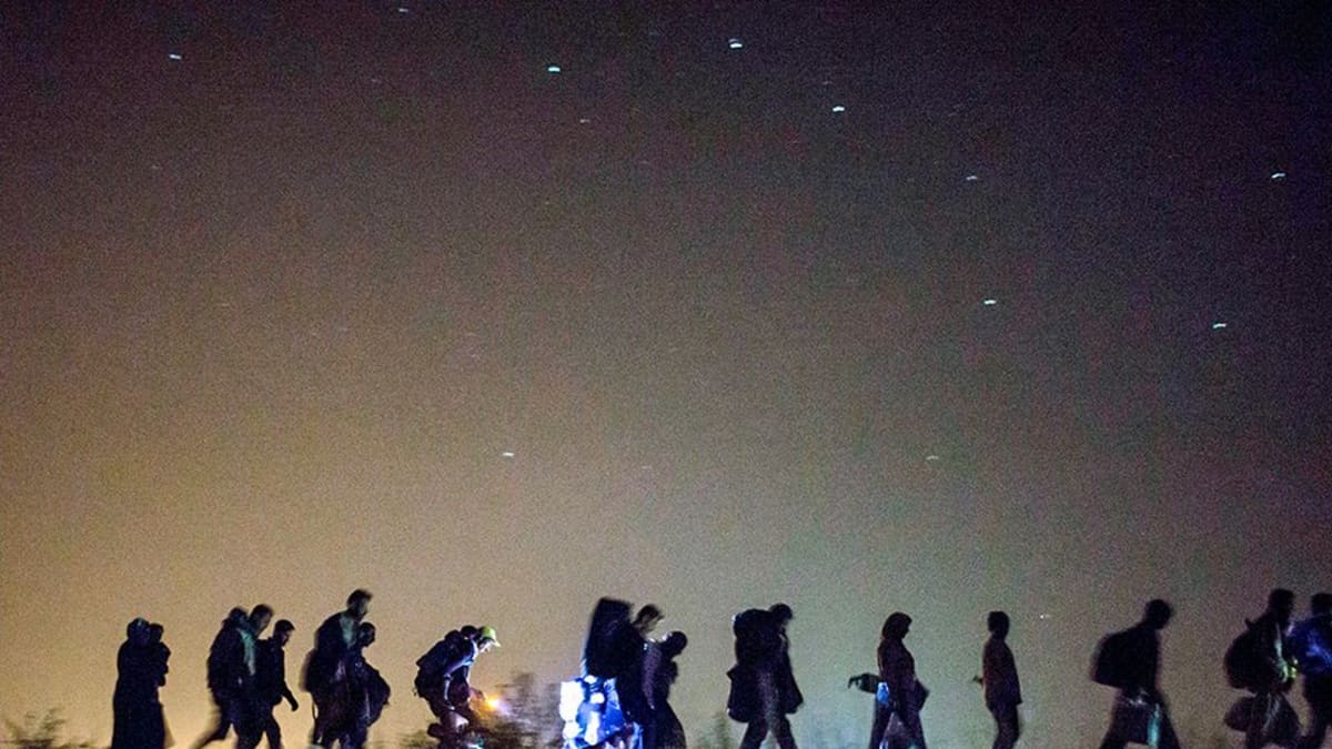 pakolaiset kävelevät jonossa yöllä