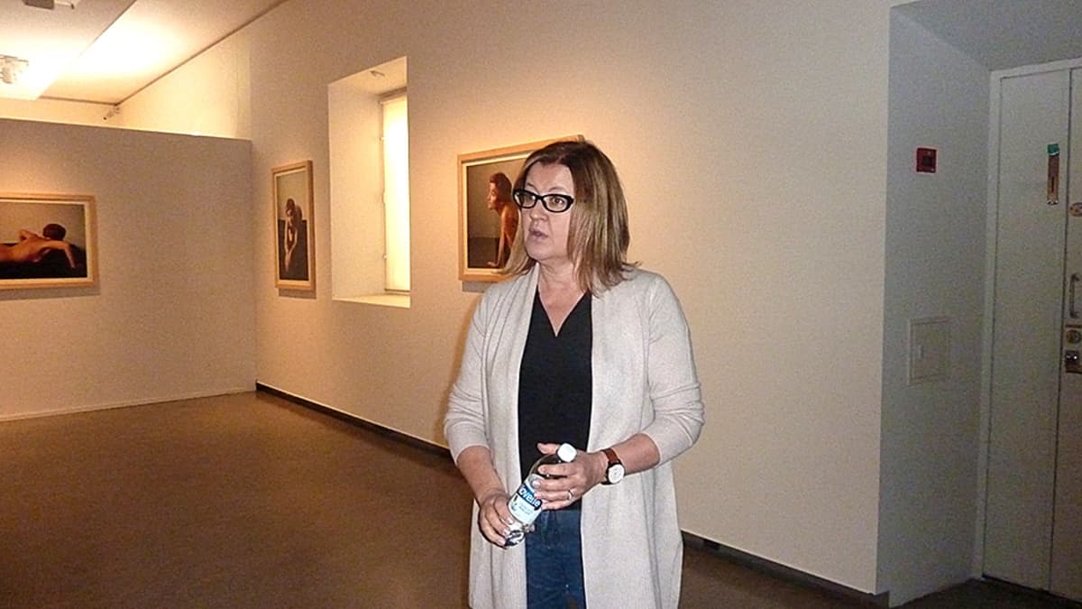 Nainen seisoo taidemuseon näyttelytilassa.