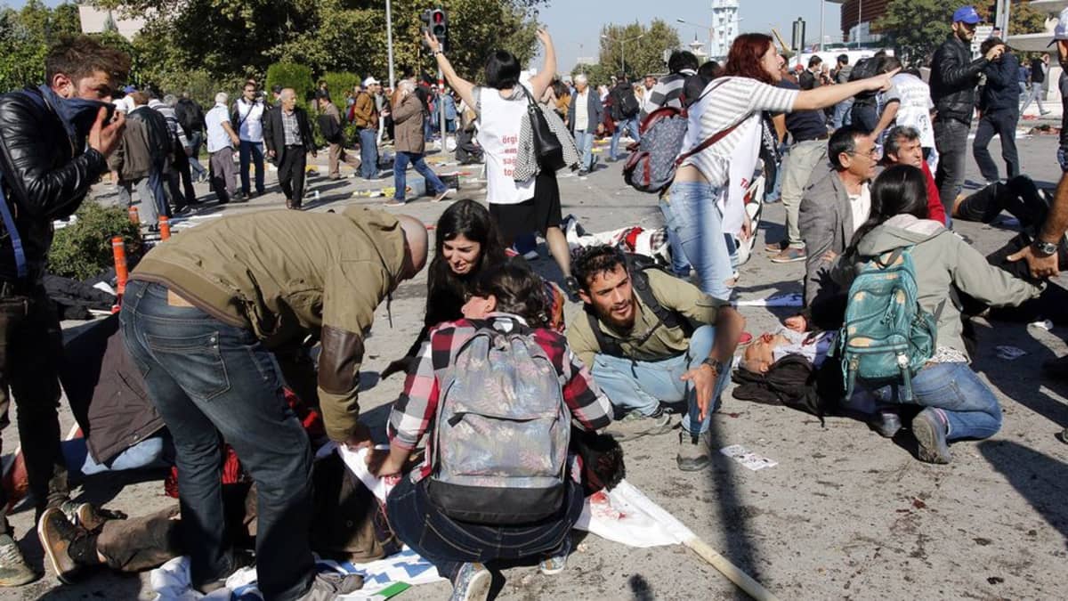 Ihmiset auttoivat loukkaantuneita räjähdyspaikalla päärautatieaseman läheisyydessä Ankarassa.