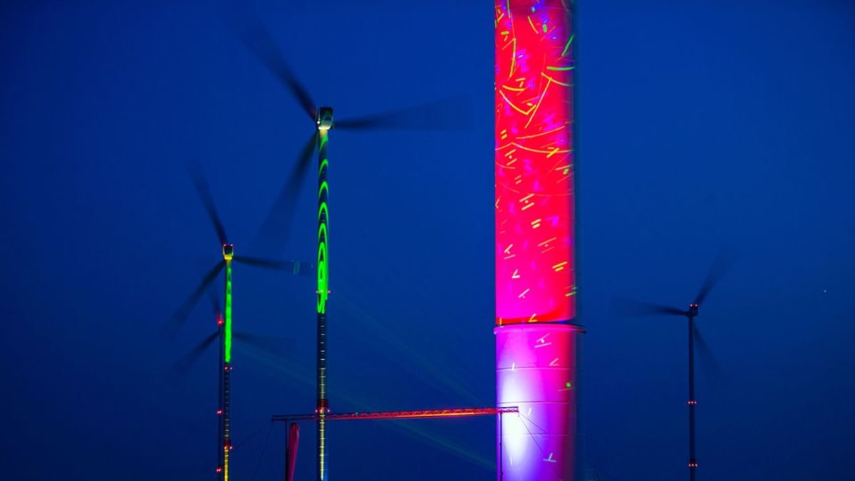 Värikkäät laservalot valaisivat 140 metriä korkeita tuulimyllyjä tuulivoimapuistossa Saksassa 24. huhtikuuta, jolloin saksalaiset viettävät uusiutuvan energian päivää.