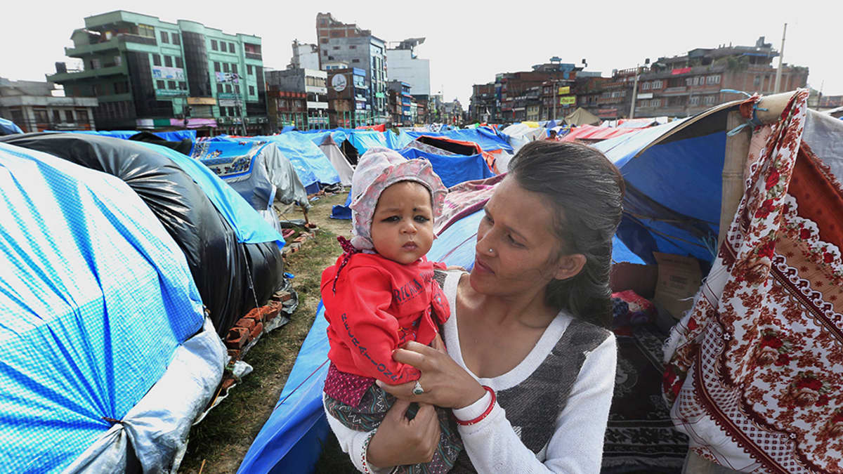 Äiti lapsensa kanssa väliaikaisessa telttaleirissä maanjäristyksen jälkeen Katmandussa.