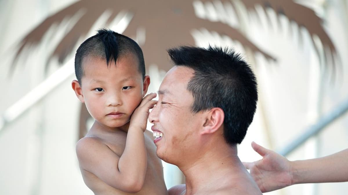 Isä viettää poikansa kanssa isänpäivää pekingiläisessä vesipuistossa.