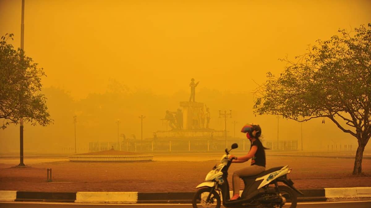 Sankka savusumu teki hengittämisestä vaikeaa ja alensi näkyvyyttä monissa kaupungeissa. Nainen ajoi moottoripyörällään savusumussa Palangkarayan kaupungissa Borneolla lokakuun lopussa.