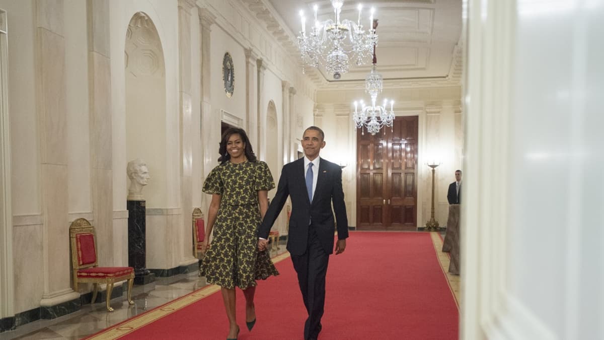 Barack Obama kävelee käsi kädessä Michelle-vaimonsa kanssa.