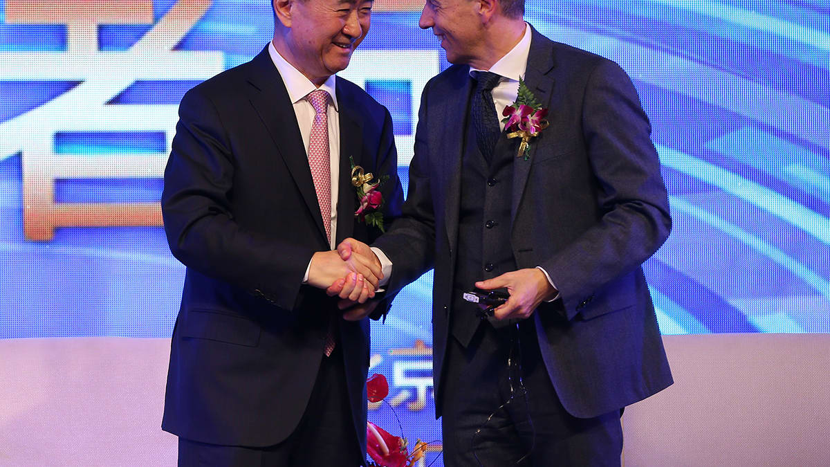 Wang Jianlin vasemmalla kättelee  Philippe Blatteria.