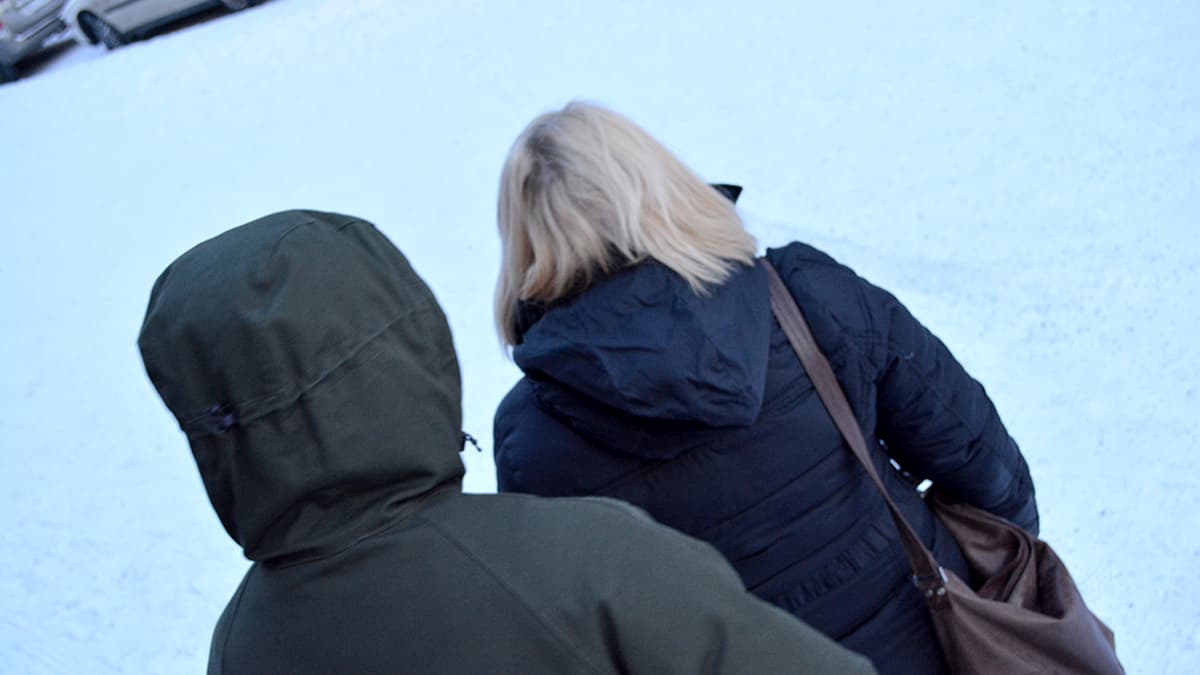 Mies lähestyy naista talvisella kadulla