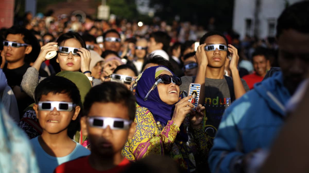 Ihmisiä auringonpimennyksen aikaan Indonesian pääkaupungissa Jakartassa. 
