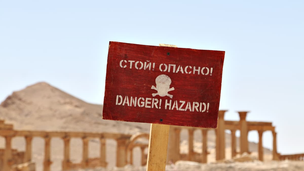 Varoituskyltti hengenvaarasta. Isis-järjestö jätti vetäytyessään räjähteitä Palmyran rauniokaupunkiin. Venäläiset sotilaat ovat raivanneet alueelta miinoja.