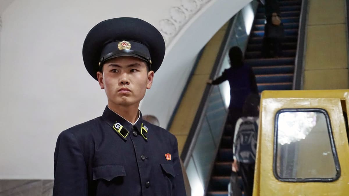 Pjongjangin metron vartija tarkasti, että ihmiset nousivat oikeita liukuportaita ylös.
