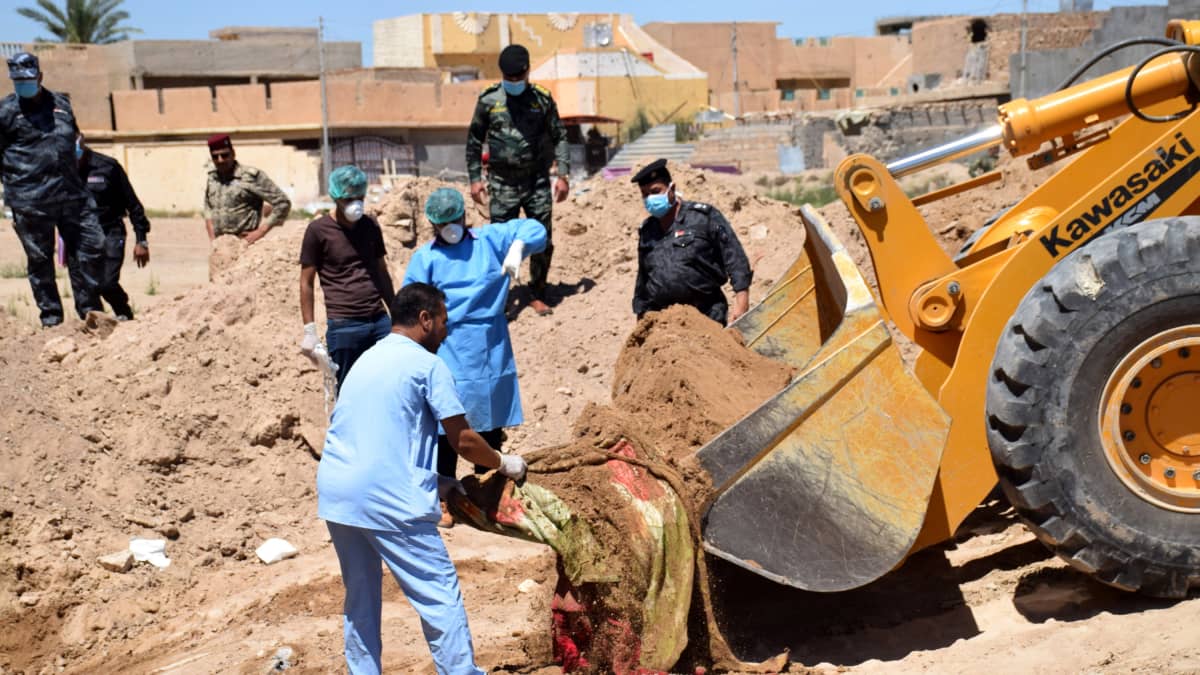 Viranomaiset tutkivat Ramadista Irakista löytynyttä joukkohautaa. Kaivinkone nostaa maasta hiekkaa, jonka joukosta paljastuu verisen näköinen kangas. Maskeilla suojatuneet viranomaiset seuraavat tilannetta.