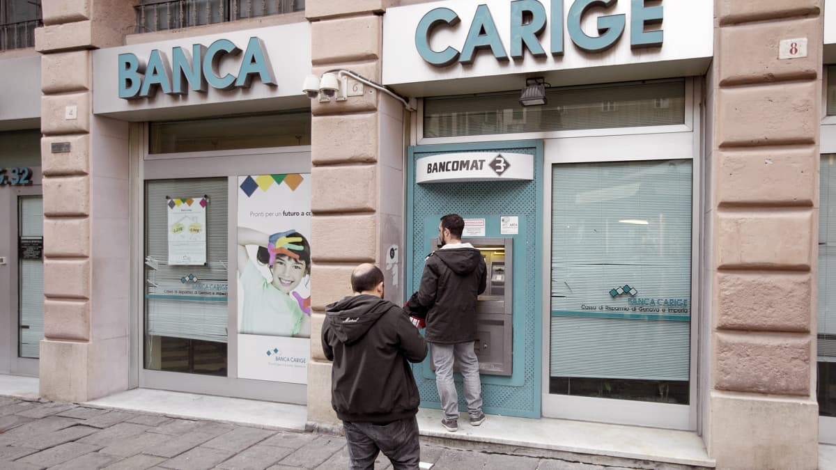 Asiakkaat jonottavat pankkiautomaatille Italian Genovassa.