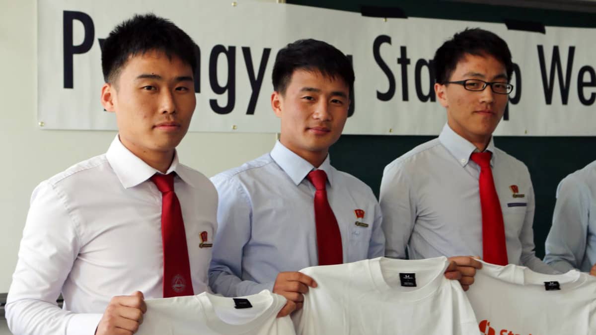 Startup Sauna Pohjois-Koreassa. Opiskelijat ovat pukeutuneet vaaleisiin kauluspaitoihin ja punaisiin kravatteihin. Kaikilla heistä on samantyyppiset lyhyet hiukset. 
