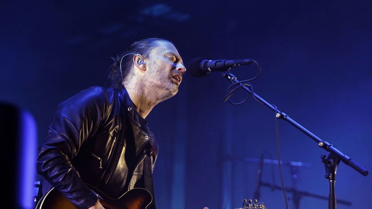 Radioheadin laulaja Thom Yorke lavalla kitaran ja mikrofonin kanssa.