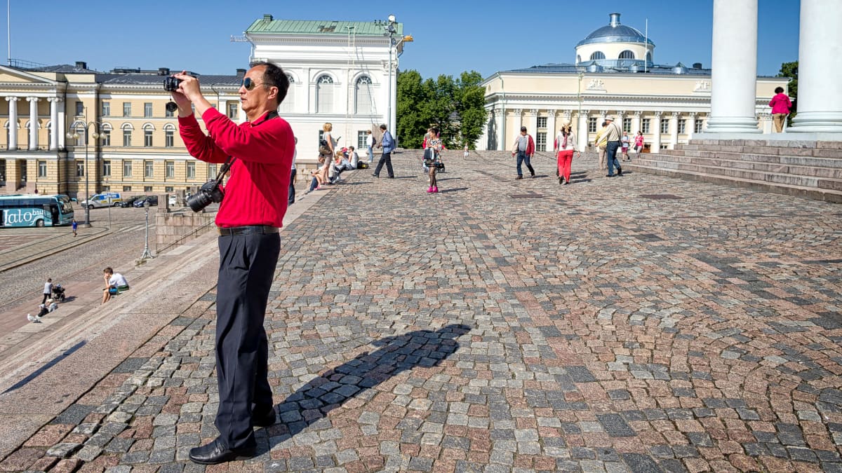 Mies kuvaa tuomiokirkon portailta.