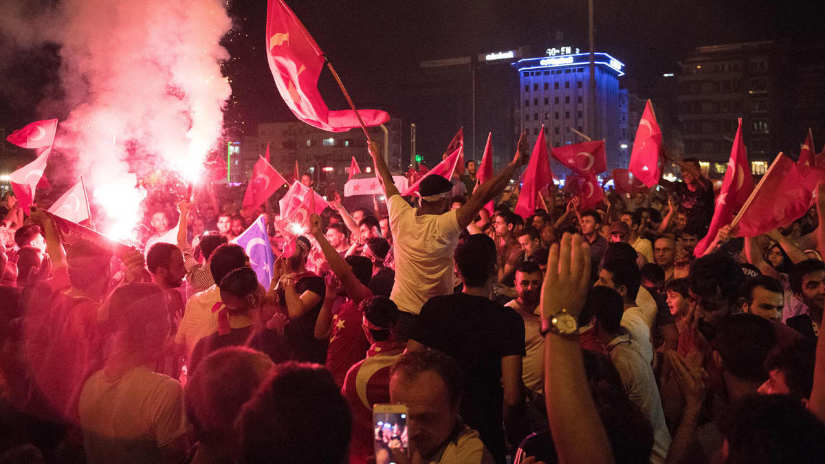 Ihmiset juhlivat epäonnistunutta vallankaappausta Taksimin aukiolla.