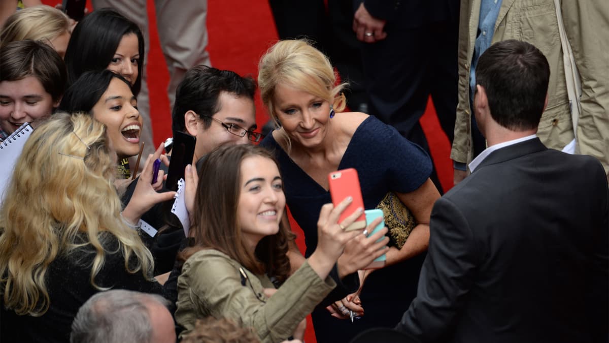 J.K. Rowling poseeraa fanien kanssa selfieen.